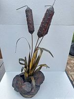 Full view of mixed-metal cattail sculpture showing overall form