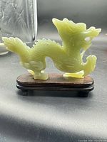 full view of jade dragon on wooden stand