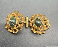 Front view of both cufflinks showing openwork design and cabochon stones