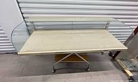 front three-quarter view of entire curved glass display case on temporary cart