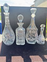 Front view of four cut crystal decanters with stoppers
