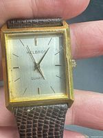 Front view of Helbros square gold-tone watch showing dial and hands