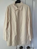 Front view of Jaeger cream long-sleeve blouse showing vertical rhinestone placket and hem/cuff trim