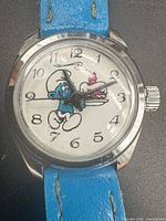 Front view of watch showing Smurf dial, case, strap