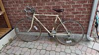 Full left-side view of bicycle against brick wall