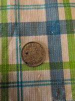 Reverse side showing 10 Cents 1938 with hole and corrosion