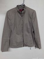 Front view of taupe-gray Dinomoda zip moto jacket on hanger