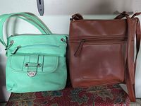 Front view of both bags showing colors, styles, hardware, closures
