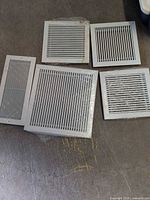 Group shot of five vent covers: three square, two rectangular