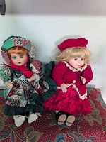 Front view of both porcelain dolls in full outfits