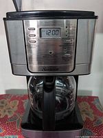Front view of Sunbeam coffee maker with digital display and carafe in place
