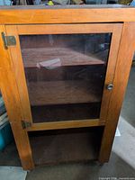 Full view of plywood cabinet with glass door closed
