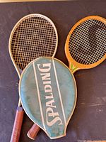 Two rackets overlapping with head cover showing Spalding logo