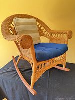 Front angled view of wicker rocking chair with cushions