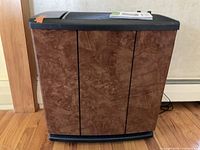 Front view of brown woodgrain console humidifier with black top and base