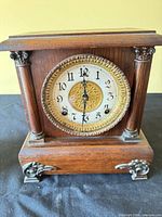Front view of mantel clock showing dial, columns, feet