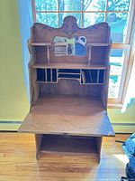 Front view of oak secretary desk with drop-front open showing interior cubbies and mirror