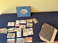 Loose postcards, blue album, brown album on table