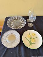 Overview showing ceramic floral plate, deviled egg plate, stack of dessert plates and two wine glasses