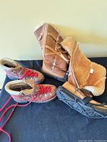 Both pairs of boots laid out showing uppers, laces, shearling lining and overall wear