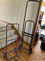Both folding steel hand trucks standing by staircase