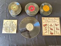 Stacks of 7-inch singles, two LPs, two visible sleeves