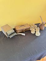 Group shot: drawers, toolbox, six glass insulators, metal cup