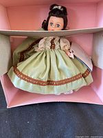 Doll in pale green dress inside box