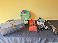 Overall lot showing toolbox, red tray with hand tools, sealed Ace garden hose, corded drill and reciprocating saw