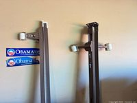 Brown angle-iron rails with white casters leaning against wall