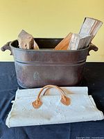 Metal wood bin with firewood and canvas carrier