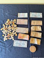 Overview of all coins, banknotes and medallion on black cloth