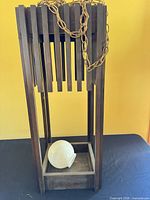 Full pendant light showing wooden frame, chain, white globe in base