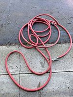 Entire hose coiled on driveway showing overall length and color