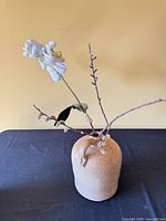 Full view of stoneware vase with artificial flower arrangement