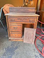 Front view of desk showing carved backsplash, four drawers, missing cabinet door