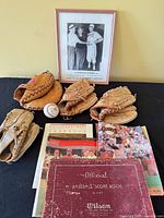 Group shot of gloves, ball, books, and framed photo