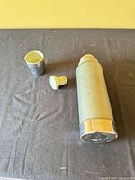 Flask lying with stopper and cup lid shown