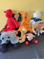 Group shot of all stuffed animals on black surface