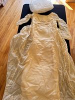 Full view of ivory wedding dress with veil placed above bodice
