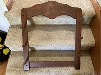 Front view of brown wood coat rack showing overall design and six pegs