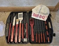 Case open showing full set of utensils, skewers, corn holders and chef hat