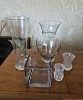 Five clear glass vases on table