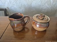 Creamer jug and lidded sugar bowl side by side showing glaze and shape