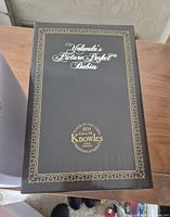 Top of black presentation box with Yolanda’s Picture-Perfect Babies gold script