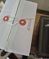 White inner box with string clasps and Jessica name