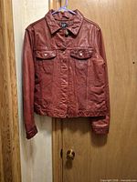 Front view of red leather GAP trucker jacket on hanger