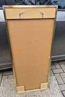 Back of rectangular mirror showing gold-tone metal frame and wire hanger