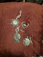 All four pewter-tone ornaments on chair