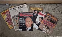 All seven magazines arrayed on carpet showing covers and condition